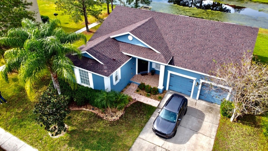 Aerial drone inspection view of a residential roof, gutters, and siding
