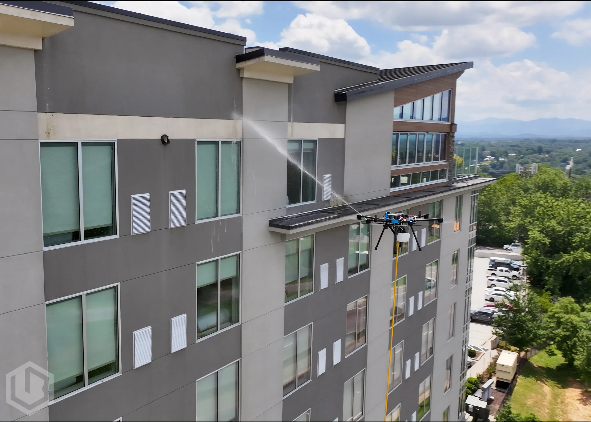 Cleaning drone pressure washing the facade of a mid-rise commercial building